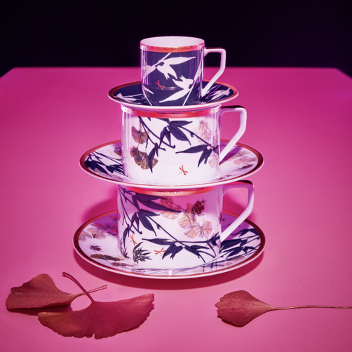 Rosenthal porcelain cups and saucers with blue bamboo design, stacked on pink background