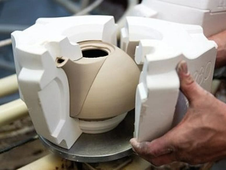 Porzellanproduktion Druckgießen Per Hand wird die Gipsform entfernt und eine Teekanne kommt zum Vorschein
