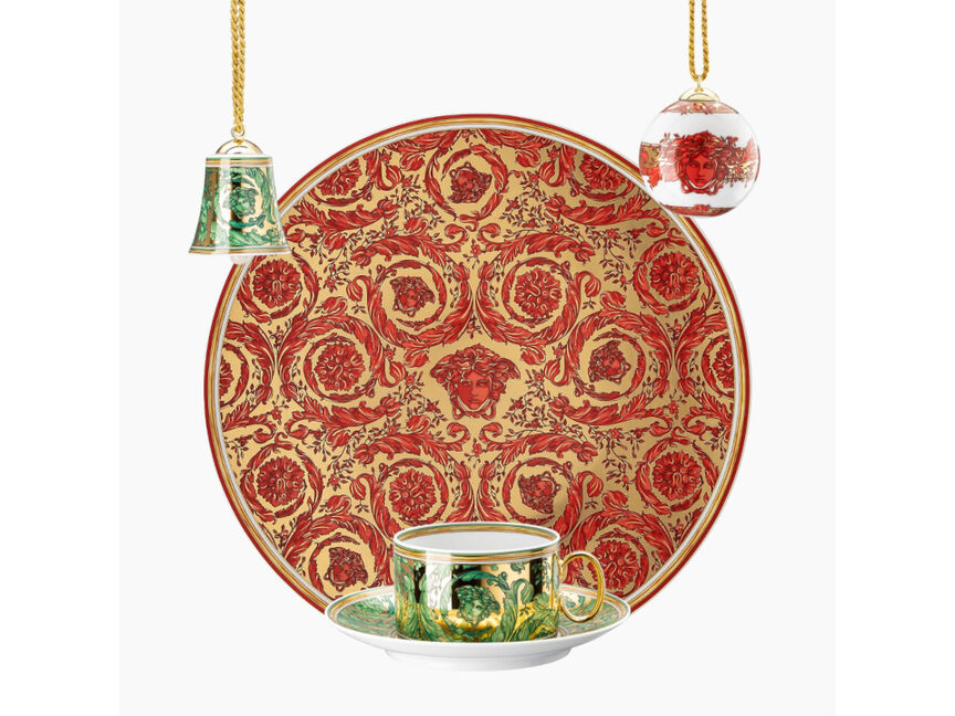 Versace Medusa von Rosenthal Weihnachtsteller in Rot und Gold mit ornamentalem Barockmuster, kombiniert mit gr&uuml;ner Tasse und Untertasse sowie dekorativen Christbaumkugeln auf hellem Hintergrund.