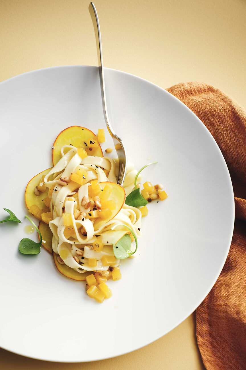 Nahe Draufsicht auf den TAC Allround Teller, der mit gelber Beete Pasta und Tagliatelle Nudeln angerichtet ist.