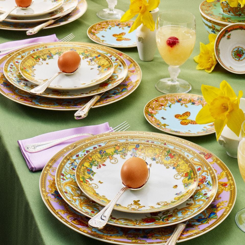 Spring-inspired Le Jardin de Versace porcelain set with butterfly and floral designs in pastel tones, styled with daffodils and colorful Easter table décor.