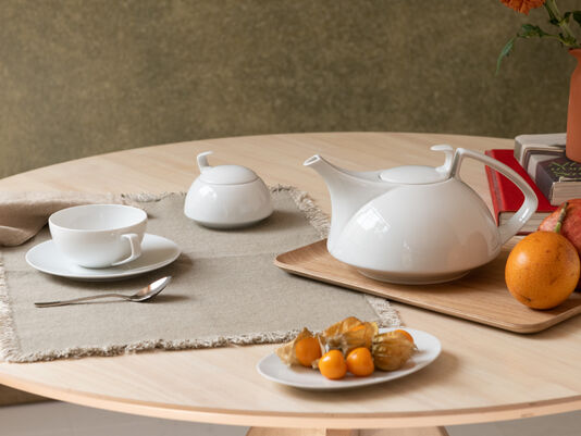 Set wooden table with a tea pot and cup with saucer