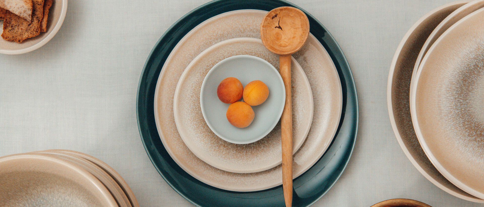 A minimalist table setting featuring Rosenthal antipasti plates in natural beige and petrol blue tones.