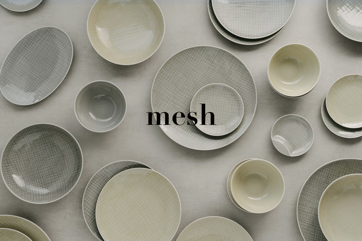 View from above of different plates, platters and bowls from Mesh Cream and Mesh Mountain, arranged in a jumble.