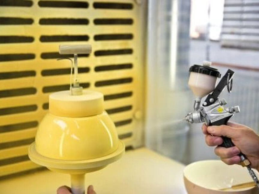 Porzellanproduktion Fond-Dekore Farbauftrag auf eine Schüssel mittels einer Spritzpistole