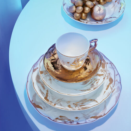 Rosenthal porcelain tableware with gold-white marble design, including cup, plates and bowl, on a modern set table