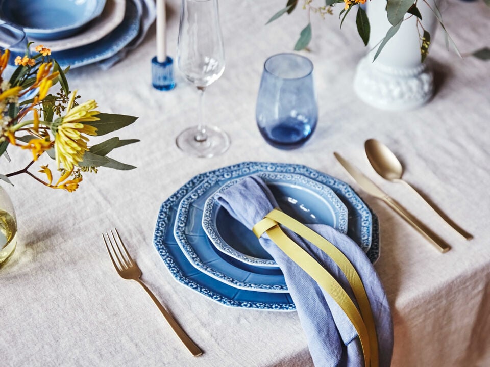 Set table with Maria Dream blue plates, golden cutlery and vase with flowers