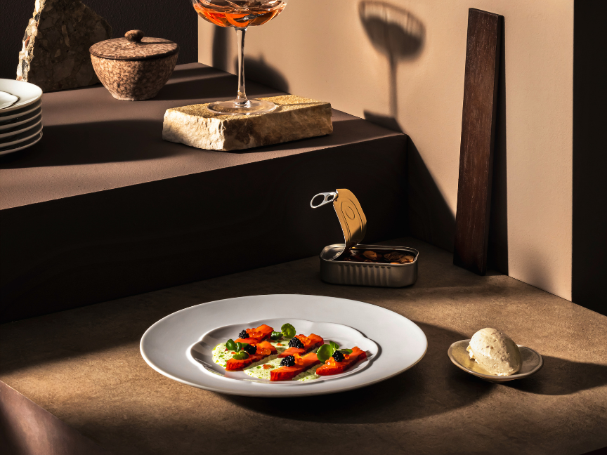 Elegant antipasti tableware by Rosenthal on a modern table setting. Small Mediterranean starters are served on a white ceramic plate, complemented by warm lighting and stylish accessories.