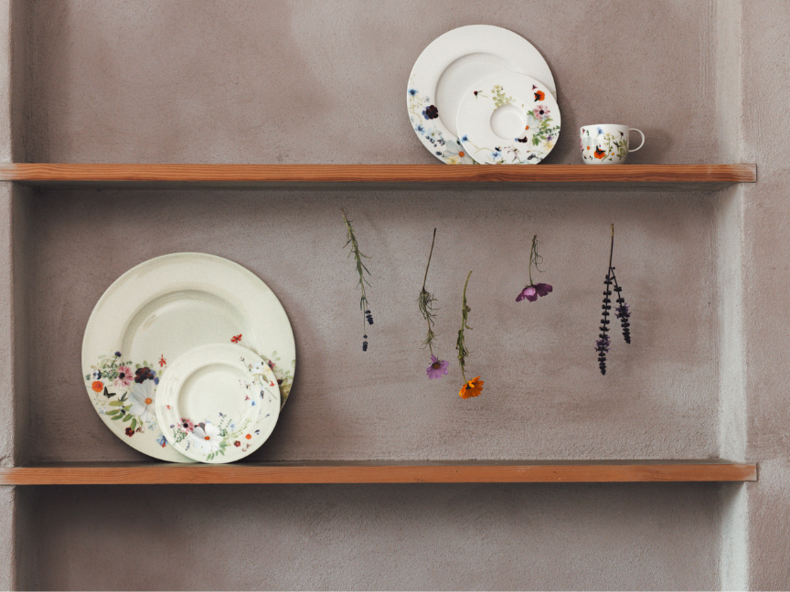 Minimalistisch arrangiertes Bone China Porzellan von Rosenthal auf offenen Holzregalen.