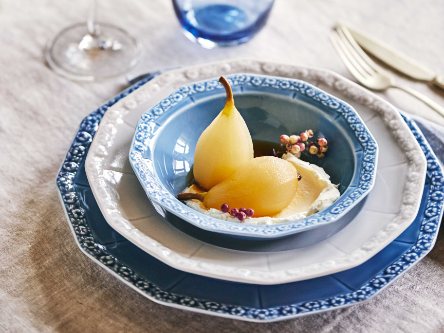 Dessert mit pochierten Birnen auf klassischem Rosenthal Maria Porzellan in Blau und Weiß, liebevoll gedeckt auf Leinentischdecke