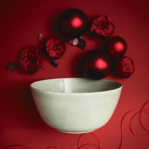 Sch&uuml;ssel von Junto Soft Shell auf dunkelrotem Hintergrund mit gleichfarbigen Kugeln und Bl&uuml;tenelementen dekoriert