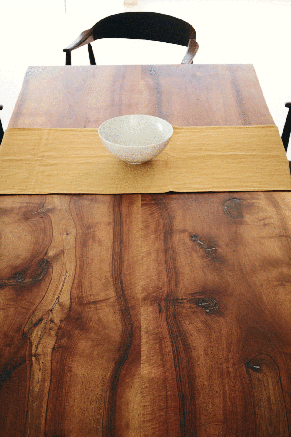 Animiertes Bild eines Holztisches mit senfgelben Tischläufern, der sich mit der TAC Dining Collection auf- und wieder abdeckt.