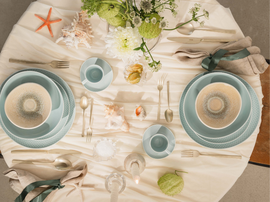 An elegantly laid dining table featuring Rosenthal antipasti plates in soft shades of beige and light blue.