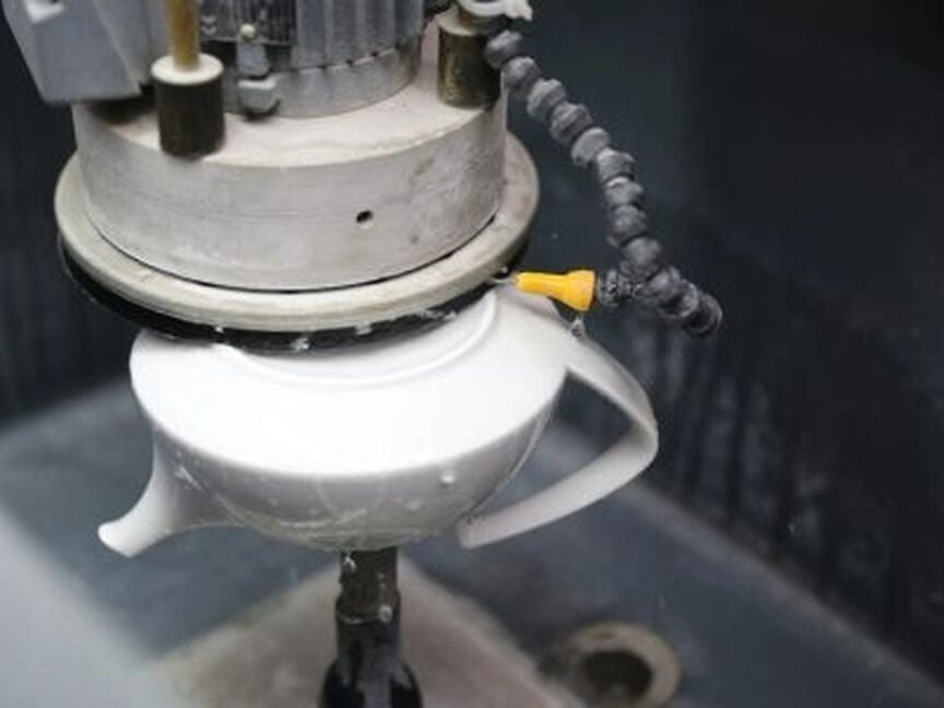 Porzellanproduktion Schleifen Darstellung des Schleifprozesses anhand der Unterseite einer TAC Teekanne