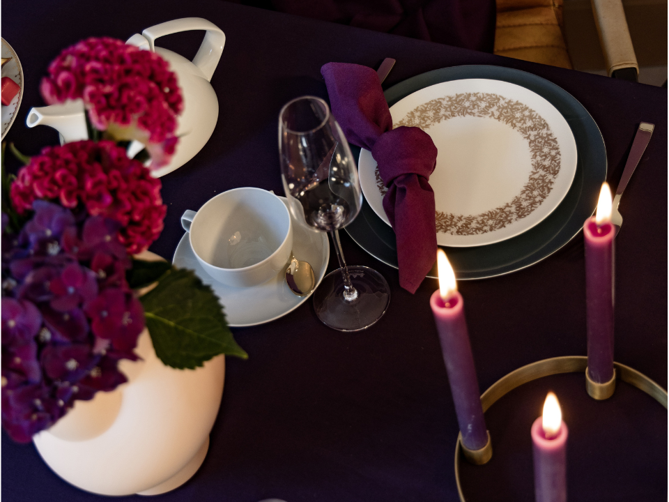 Festlich gedeckter Tisch mit Rosenthal-Porzellan, violetten Kerzen und floralen Akzenten in satten Beerentönen
