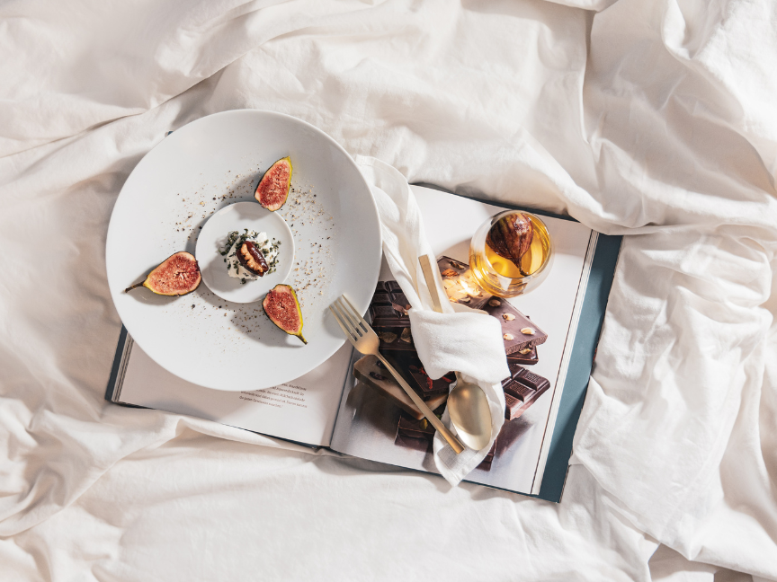 Elegant Rosenthal tableware with a beautifully presented dessert on a book, surrounded by delicate fabrics.