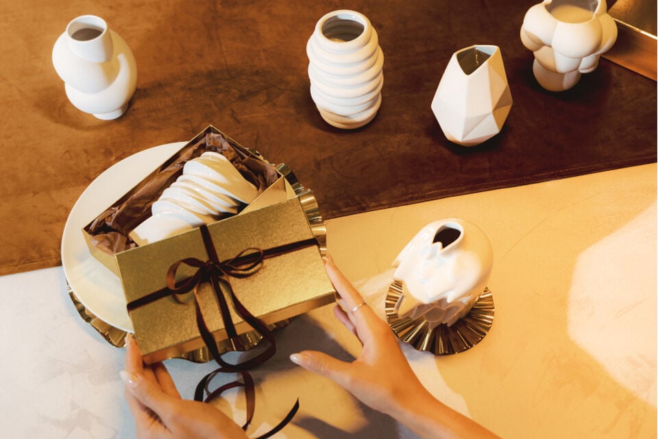 Weiße Rosenthal Midi Vasen in einer goldenen Geschenkbox, die von einer Frau geöffnet wird