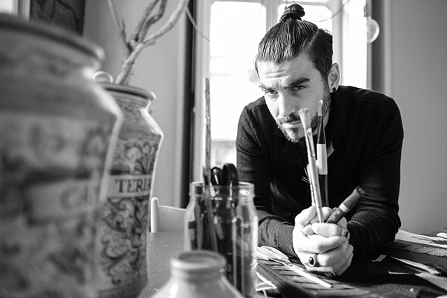 Schwarz-wei&szlig; Fotografie von Designer Gianni Cinti in einem Atelier, mit Pinseln in der Hand