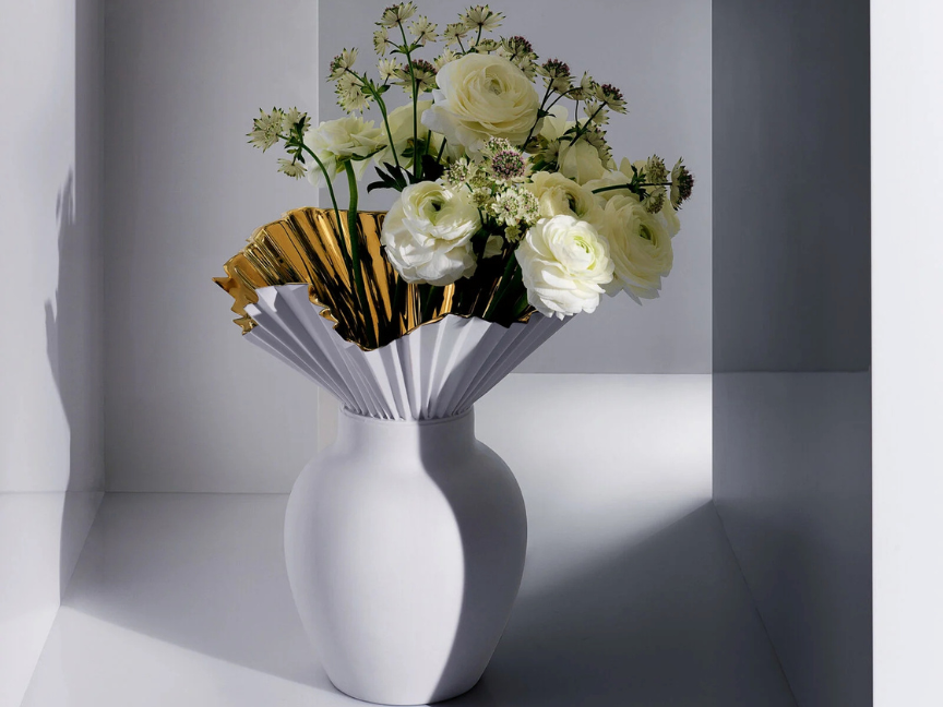 Rosenthal Falda Vase mit goldfarbenem F&auml;cherdekor und wei&szlig;en Blumen im Licht-Schatten-Spiel