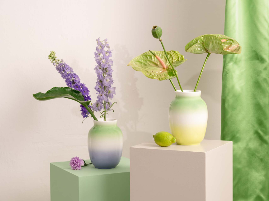 Farbverlaufende Rosenthal Vasen mit lila und gr&uuml;nen Blumen auf pastellfarbenem Sockel