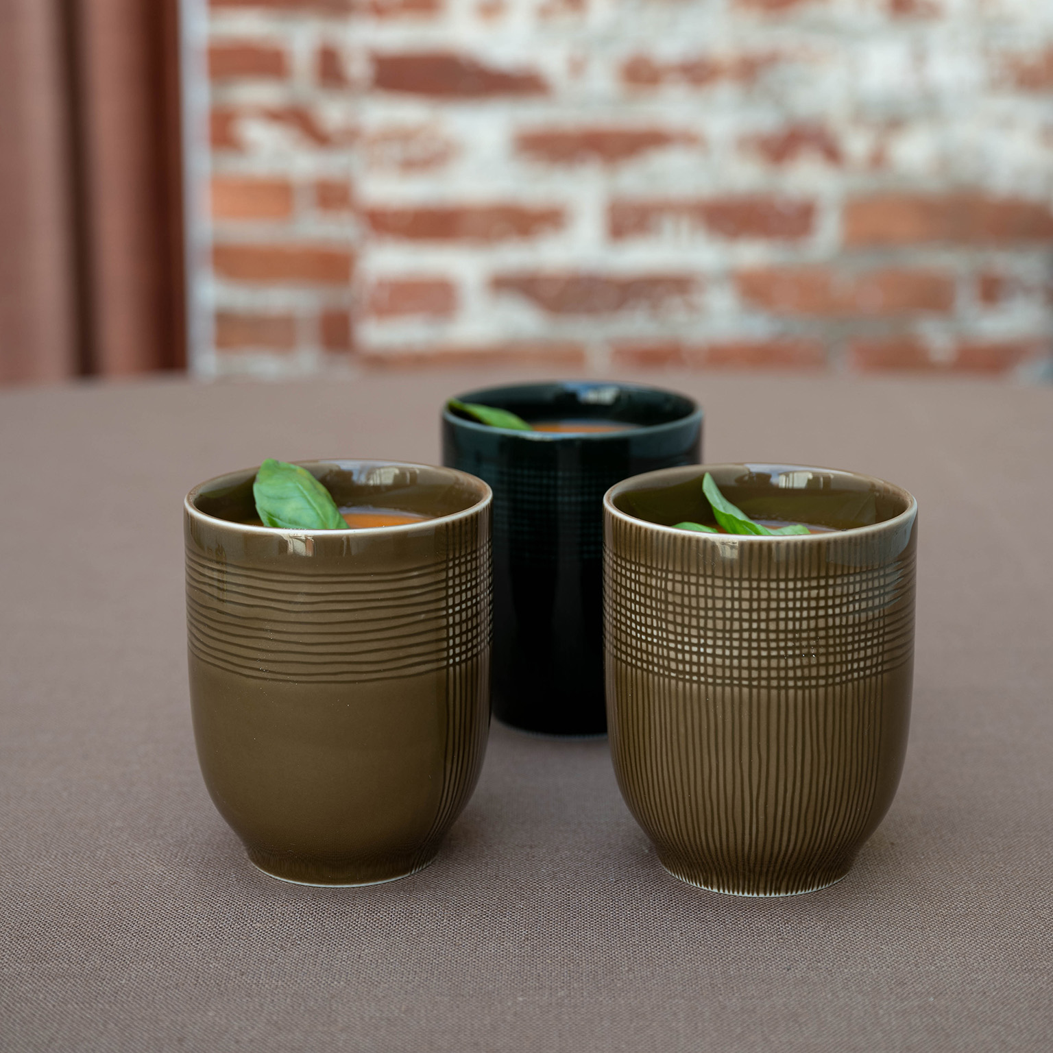 MUCA mug in the colours Wood and Forest filled with soup and basil.