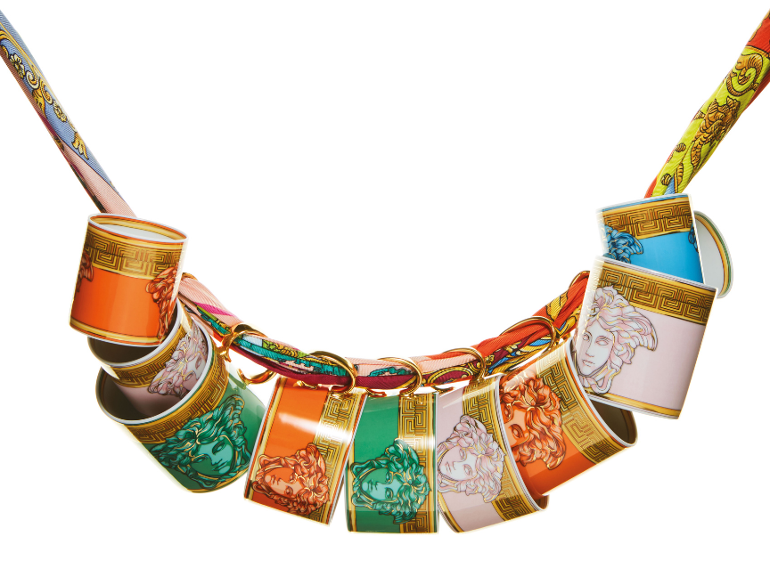 Colorful porcelain mugs with classical head motifs hanging on a patterned strap