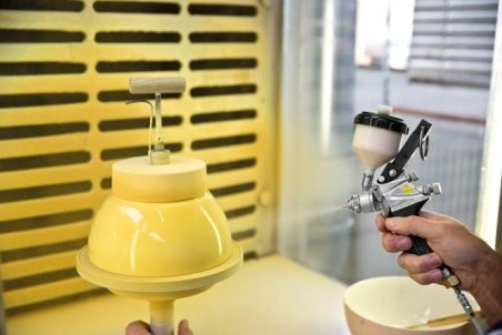Colour application on a bowl by means of a spray gun
