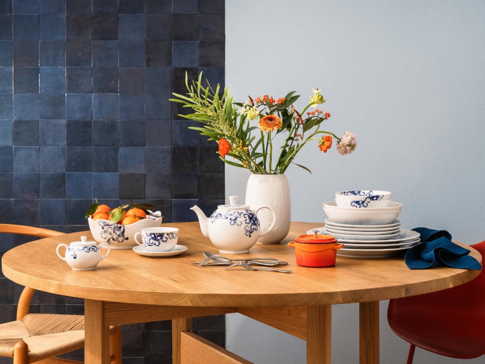 Set wooden table with the true blue collection and a vase with flowers