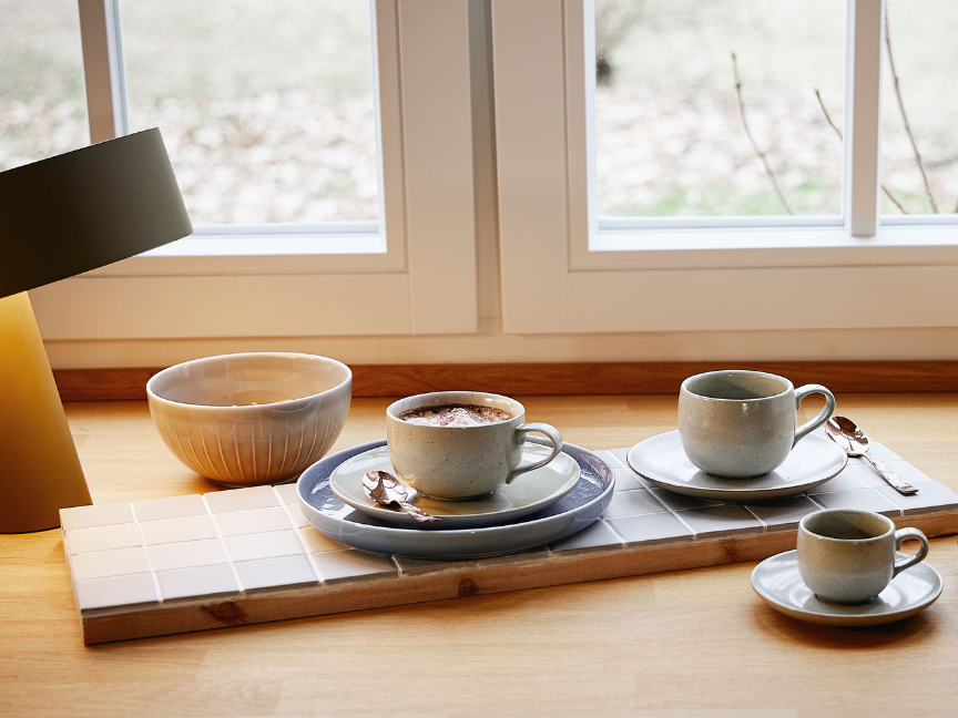 Joyn Kaffeetassen mit passenden Untertassen platziert vor K&uuml;chenfenster